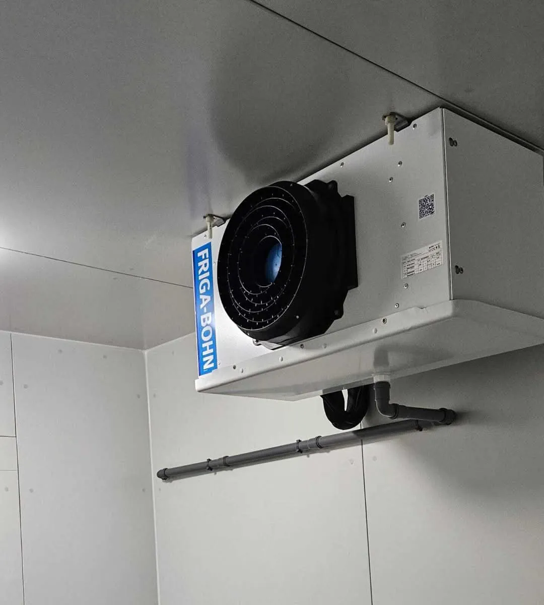 Installation d'un évaporateur dans une chambre froide pour extraire l'air chaud.